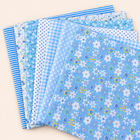 Blue cotton fabric bundle — seven 25 cm squares on cream