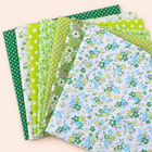 Green cotton fabric bundle — seven 25 cm squares on cream