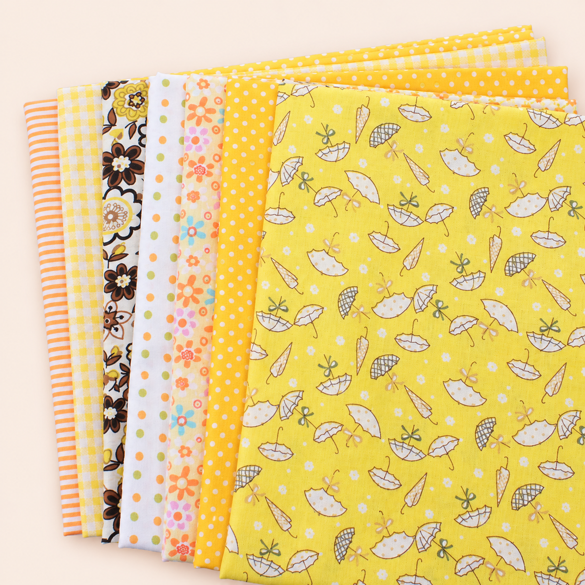 Yellow cotton fabric bundle — seven 25 cm squares on cream