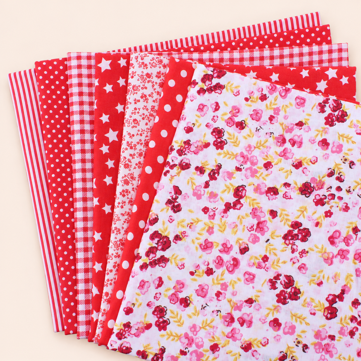 Red cotton fabric bundle — seven 25 cm squares on cream