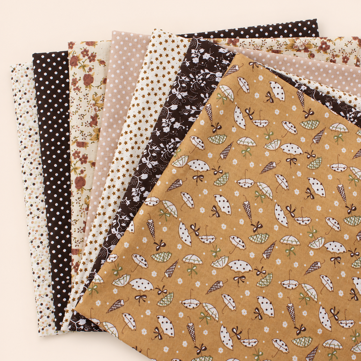Brown cotton fabric bundle — seven 25 cm squares on cream