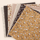 Brown cotton fabric bundle — seven 25 cm squares on cream