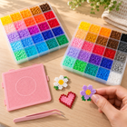Example fuse bead flower and heart projects beside colour trays; finished projects not included